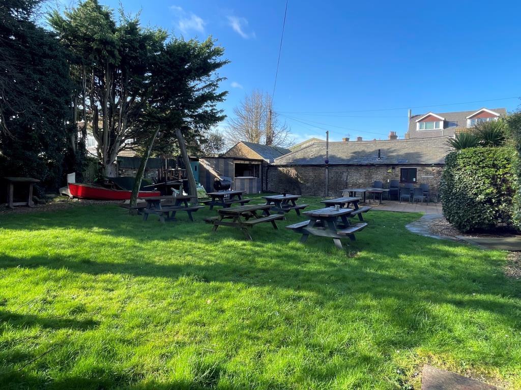 Lot: 117 - PUBLIC HOUSE WITH MANAGER'S FLAT, FIVE GUEST ROOMS, COMMERCIAL UNIT, GARDENS AND PARKING - Pub garden with tables and whale bones